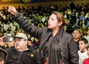 A Chicago Public Schools parent speaks out against closures at a packed hearing in Pilsen